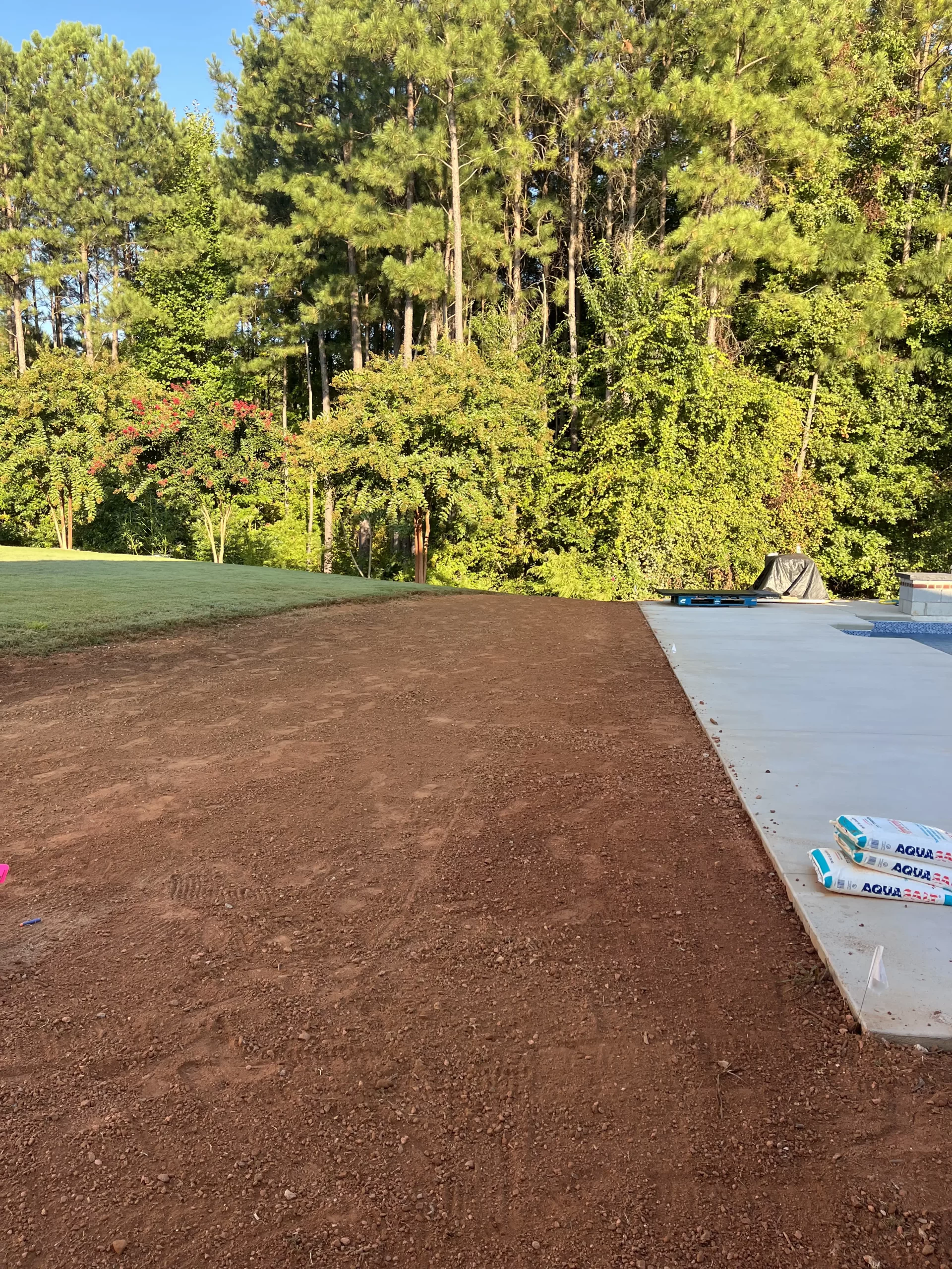 our grading contractor services performing a final grading adjacent to a pool